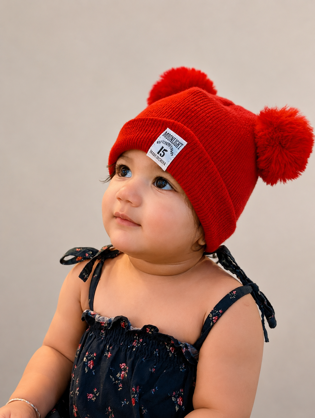 Saanvi wearing a red pom-pom hat