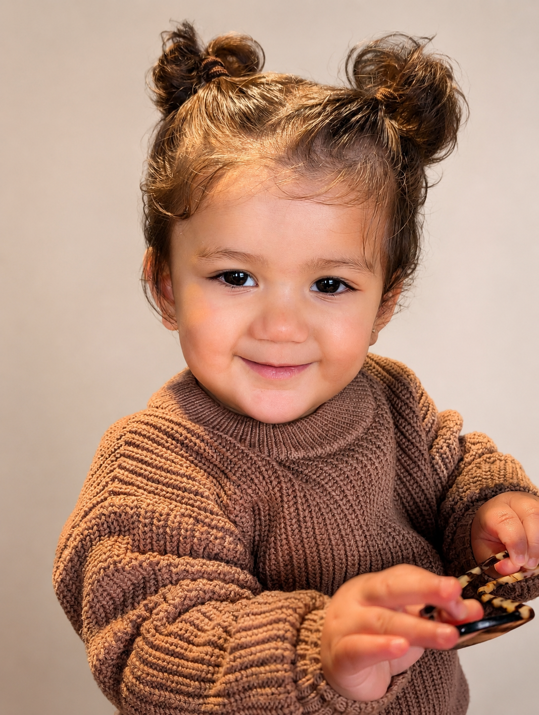 Saanvi in a brown knit sweater, smiling at the camera